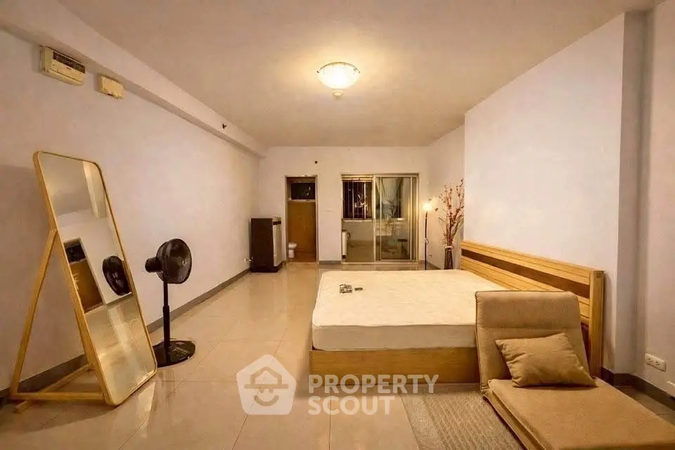 Spacious bedroom with modern decor and large mirror, perfect for relaxation and comfort.