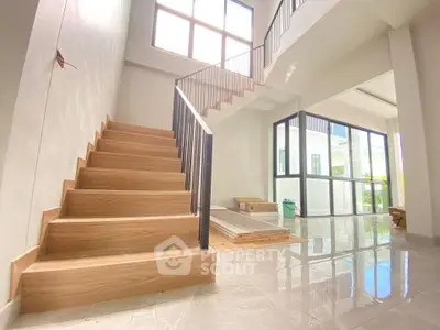 Spacious modern living room with elegant staircase and large windows