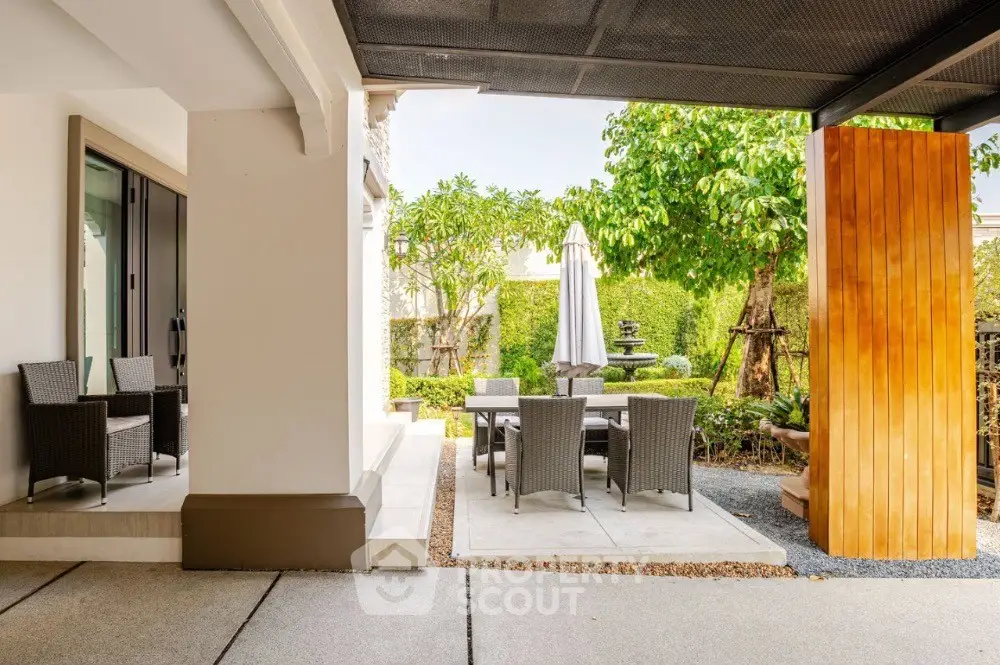 Luxurious outdoor patio with elegant dining set and lush garden view, perfect for entertaining and relaxation.