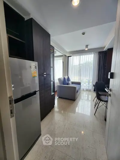 Modern apartment interior with sleek kitchen and cozy living area, featuring natural light and contemporary design.