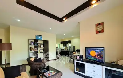 Spacious living room with modern decor and open layout leading to kitchen area.