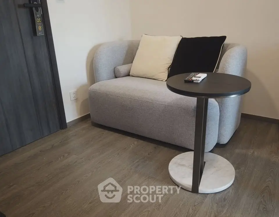 Cozy living room with modern sofa and sleek side table on wooden flooring.