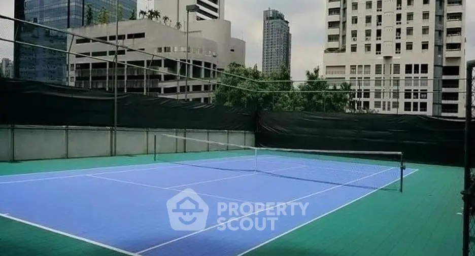 Urban rooftop tennis court with city skyline view