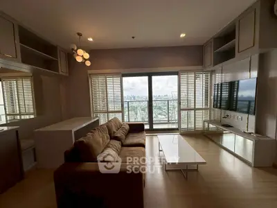 Spacious living room with stunning city view, modern furnishings, and ample natural light.