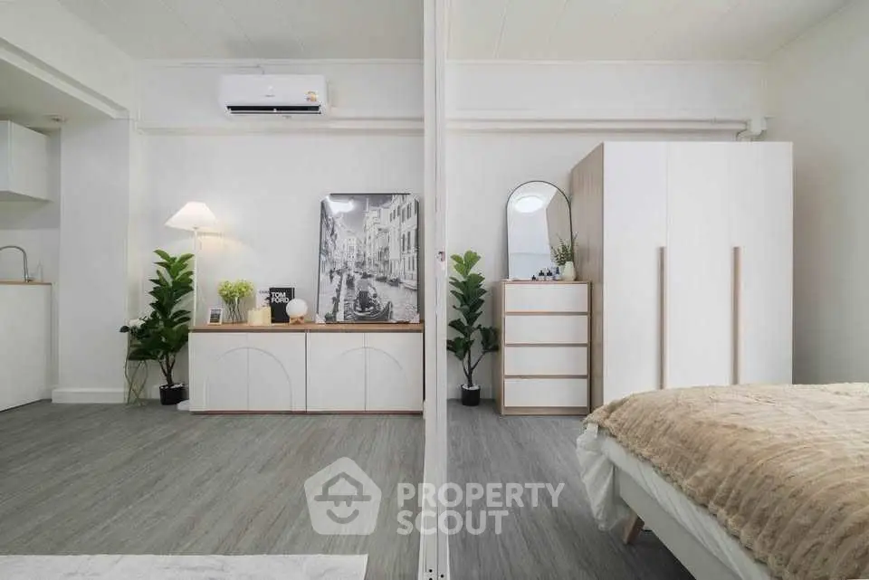 Modern bedroom with stylish decor, featuring a cozy bed, sleek wardrobe, and elegant lighting in a bright interior.