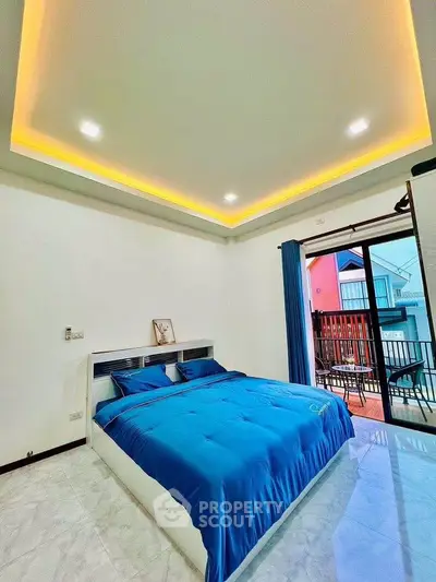 Modern bedroom with blue bedding and balcony access in a stylish home.