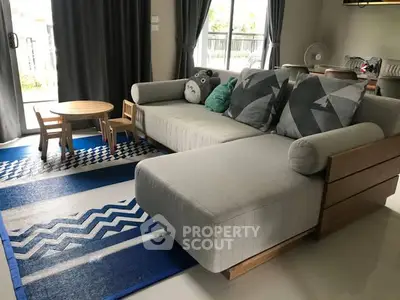 Spacious living room with modern sofa and playful decor, perfect for family gatherings.