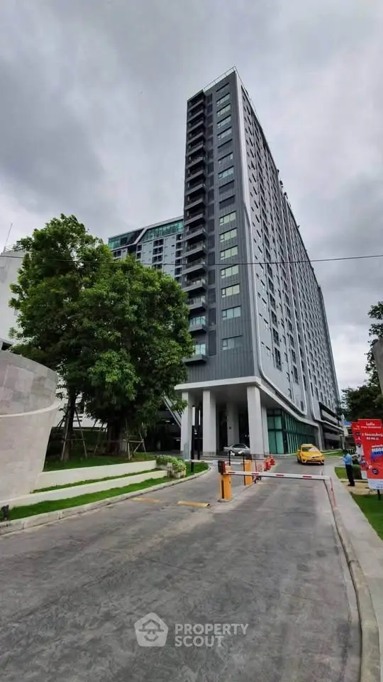 Modern high-rise building with sleek design and lush greenery, perfect for urban living.