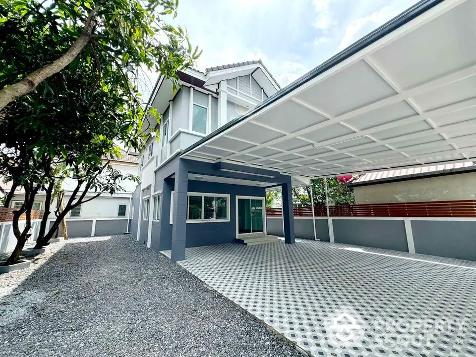 Modern two-story house with spacious carport and gravel driveway