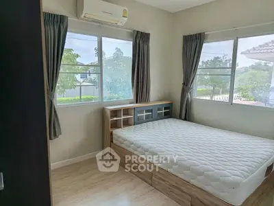 Cozy bedroom with large windows and built-in storage bed in a serene neighborhood.