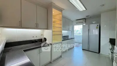 Spacious modern kitchen with sleek cabinetry and city view, featuring a large fridge and ample counter space.