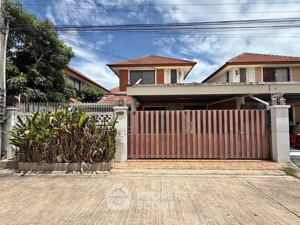 Charming suburban house with red-tiled roof and gated driveway, perfect for family living.