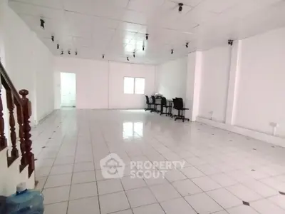 Spacious open-plan office space with tiled flooring and ample natural light