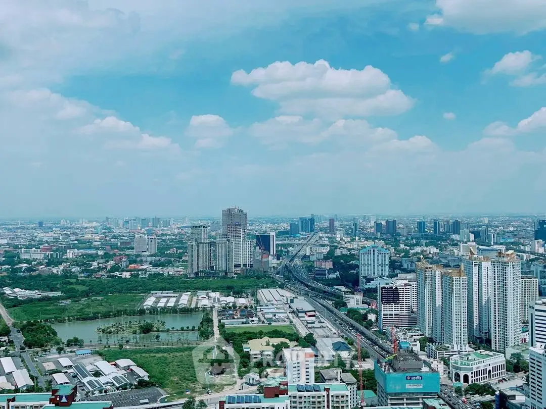 Stunning cityscape view showcasing urban skyline and lush greenery under a clear blue sky.