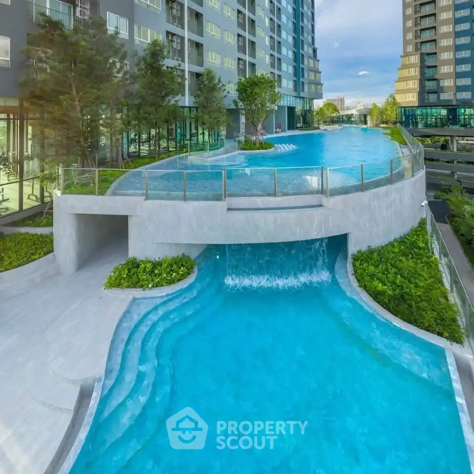 Luxurious high-rise building with stunning multi-level swimming pool and lush greenery.
