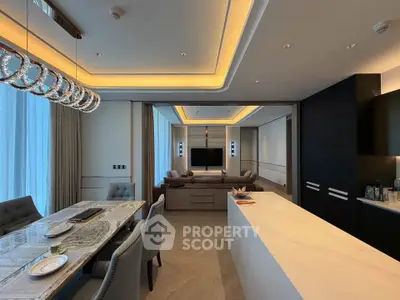Luxurious open-plan living room with elegant dining area and modern kitchen, featuring stylish lighting and sleek design.