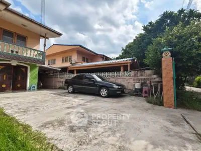 Charming suburban home with spacious driveway and lush greenery, perfect for family living.