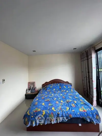 Spacious bedroom with colorful bedding and natural light