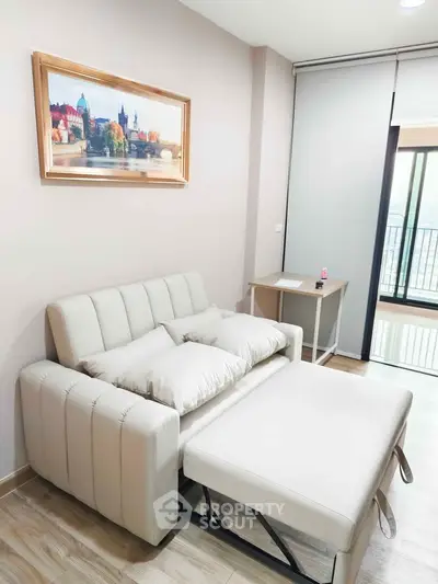 Modern living room with stylish sofa bed and balcony view, perfect for urban living.