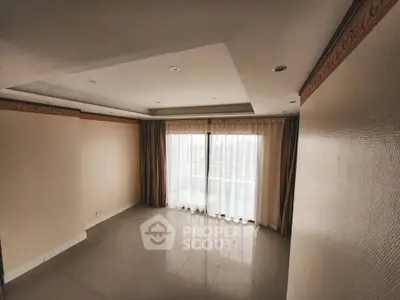 Spacious empty living room with large windows and elegant curtains