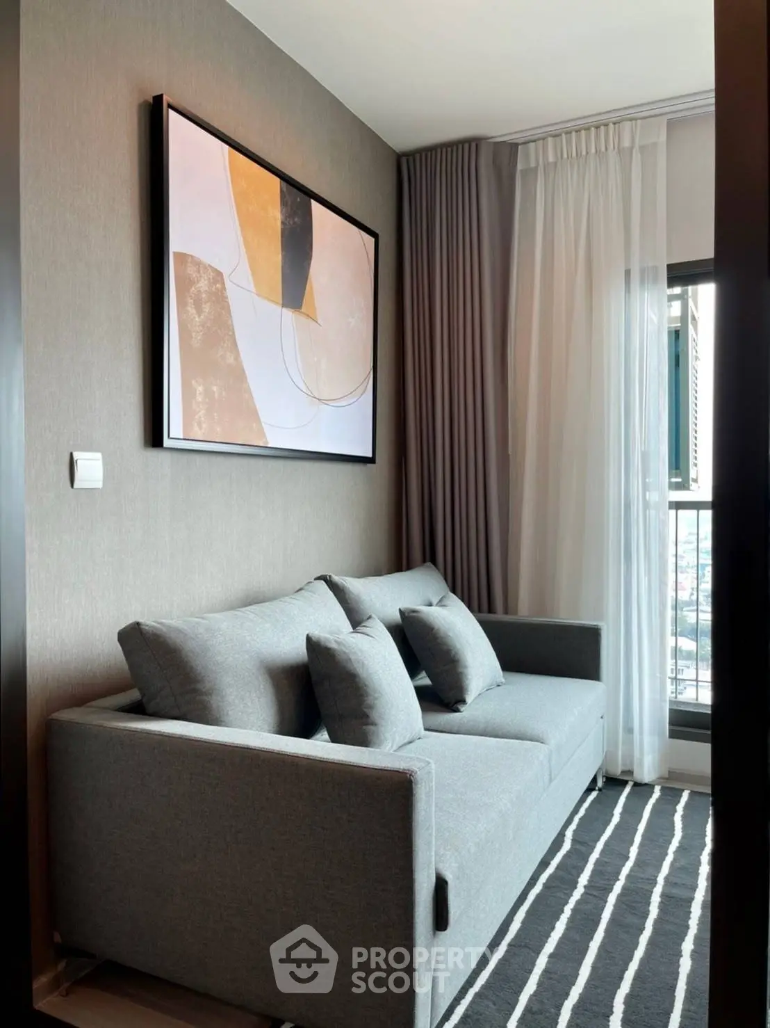 Stylish modern living room with gray sofa and abstract art
