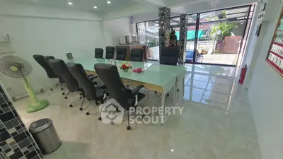 Spacious office space with modern glass table and executive chairs, ideal for meetings and business gatherings.
