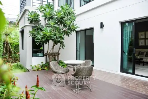 Modern patio with stylish outdoor furniture and lush greenery