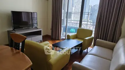 Spacious living room with modern furniture and city view balcony in urban apartment.