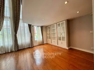 Spacious living room with elegant hardwood floors and large windows for natural light.