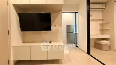 Modern living room with wall-mounted TV and sleek kitchen view