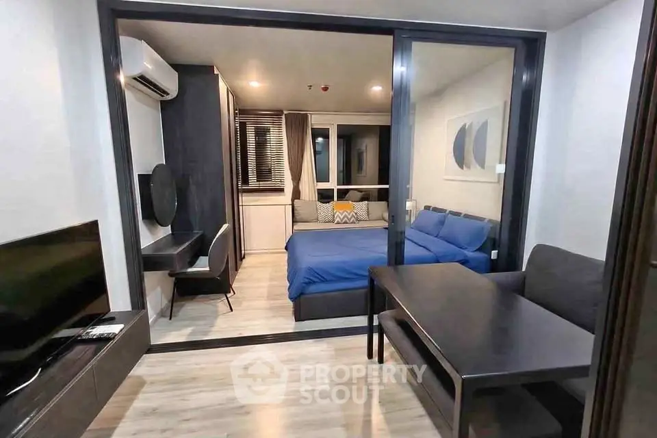 Modern studio apartment with sleek design, featuring a cozy bedroom and stylish living area.