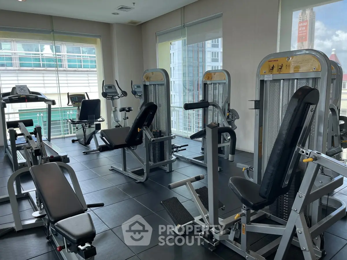 Modern gym with state-of-the-art fitness equipment and large windows for natural light.