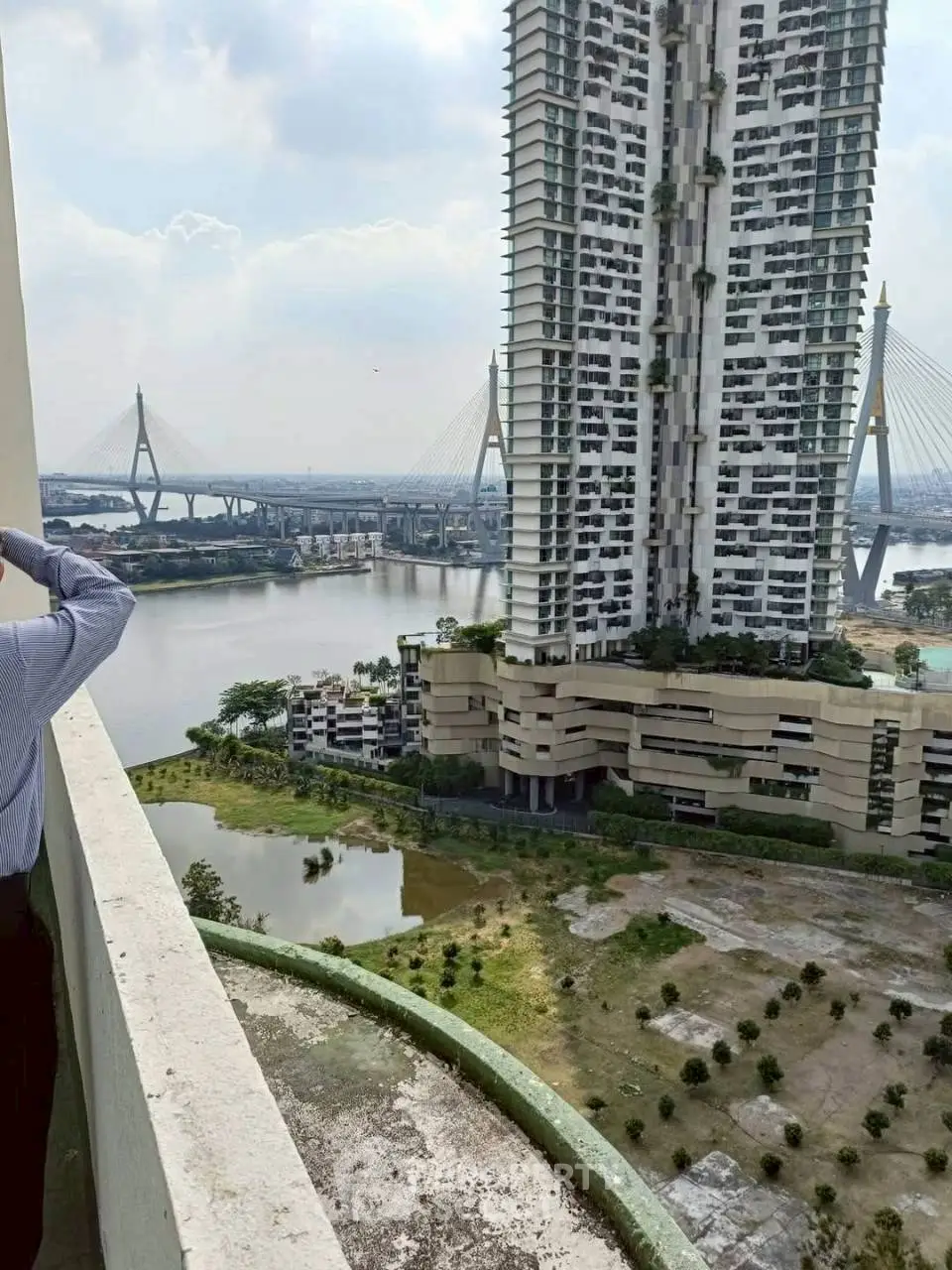 Stunning river view from high-rise building balcony with iconic bridge in the background.