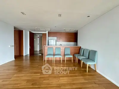 Spacious open-plan living area with wooden flooring and modern kitchen.