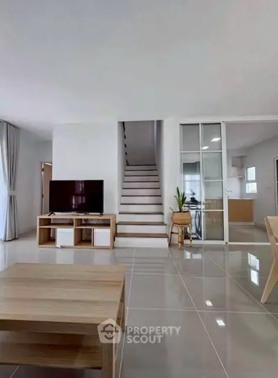 Modern living room with sleek staircase and open layout design
