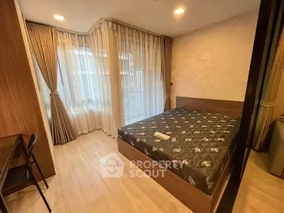 Cozy bedroom with modern furnishings and large windows for natural light.