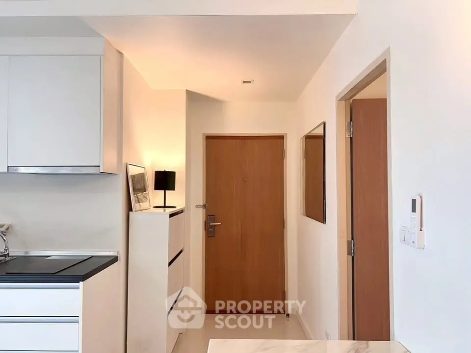 Modern apartment entrance with sleek kitchen and minimalist decor