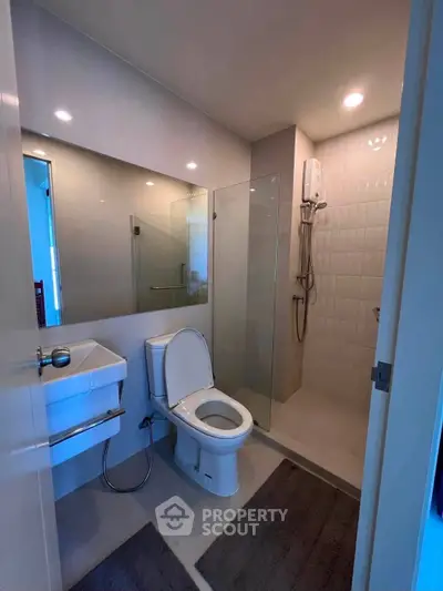 Modern bathroom with glass shower and sleek fixtures in a contemporary apartment.