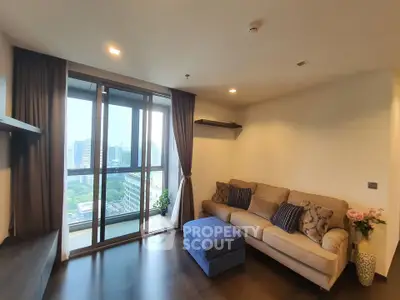 Modern living room with city view, cozy sofa, and elegant decor in high-rise apartment.