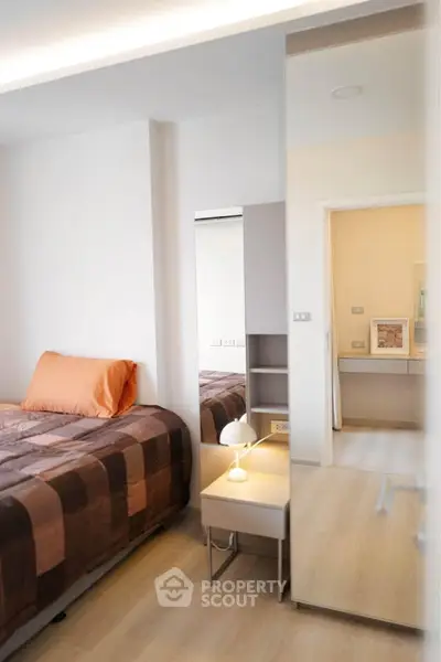 Modern bedroom with stylish decor and cozy ambiance, featuring a single bed and elegant lighting.