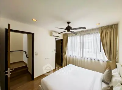 Bright and airy bedroom with modern ceiling fan and large window