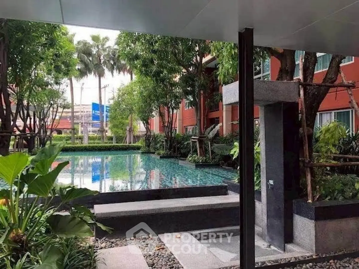 Luxurious residential pool area surrounded by lush greenery and modern architecture.