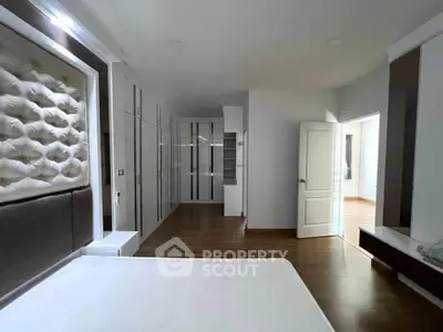 Spacious modern bedroom with elegant design and ample storage space.