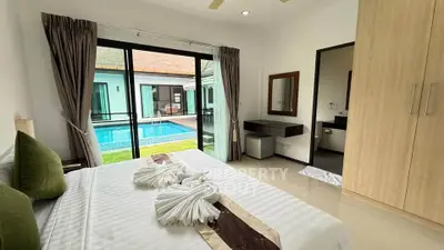 Luxurious bedroom with pool view in modern villa, featuring elegant decor and ample natural light.