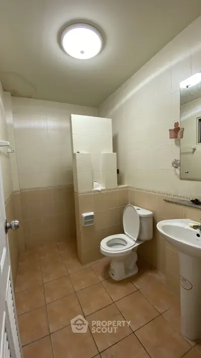 Spacious bathroom with modern fixtures and neutral tiles, ideal for comfort and functionality.