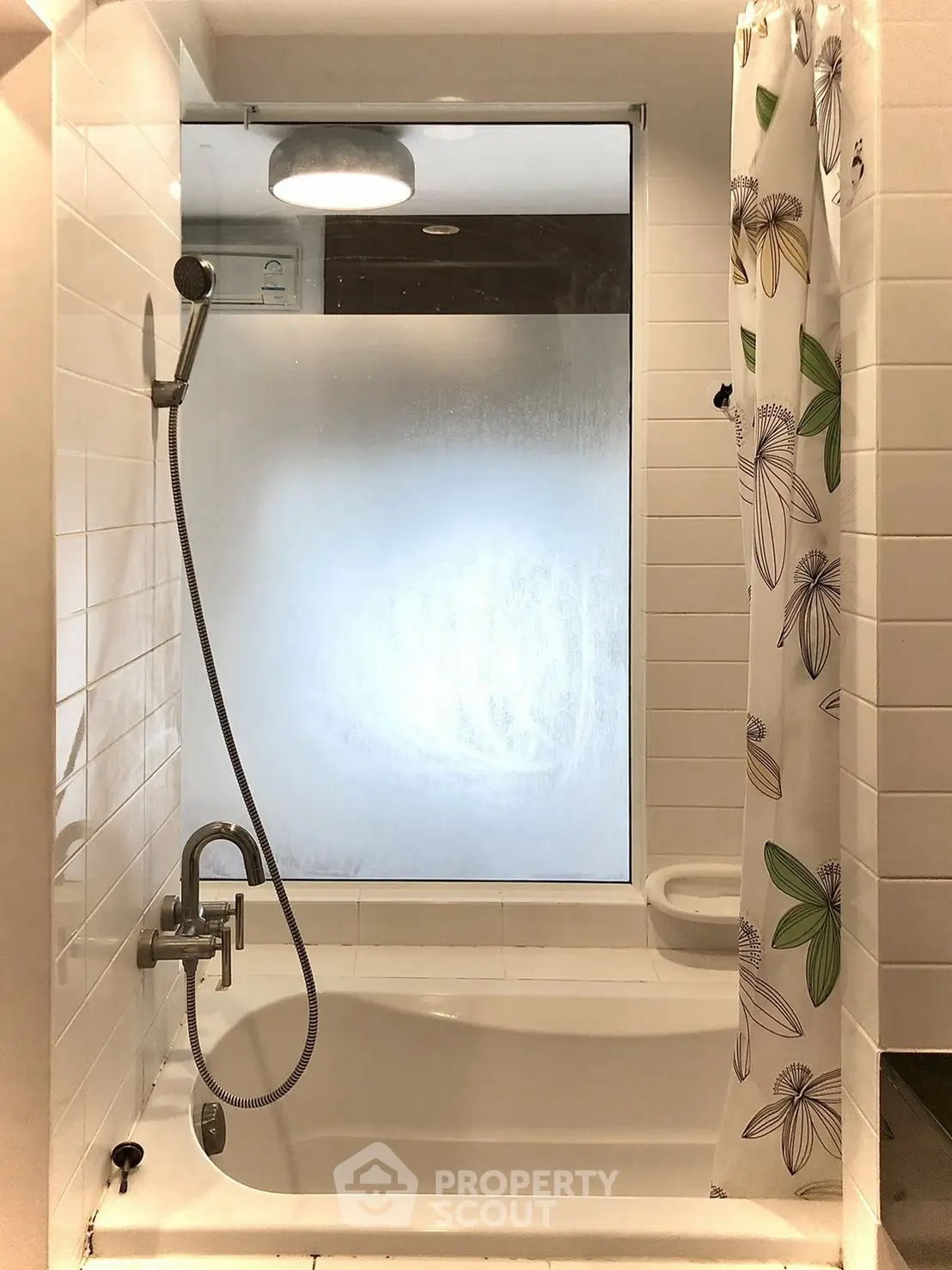 Modern bathroom with bathtub and floral shower curtain in bright lighting.