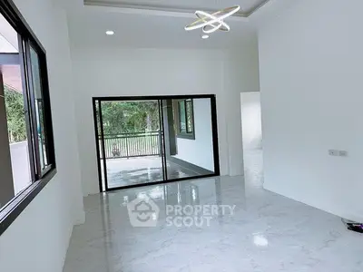 Spacious modern living room with large windows and elegant lighting