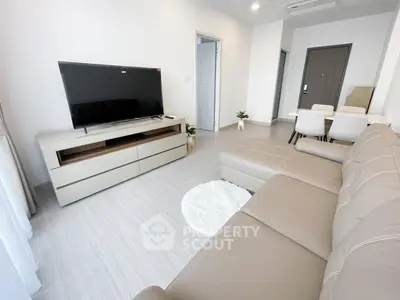 Modern living room with sleek furniture and large TV, perfect for relaxation.