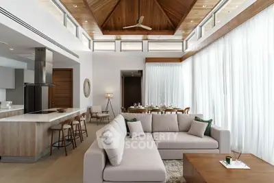 Luxurious open-plan living room with modern kitchen and elegant dining area, featuring high ceilings and natural light.