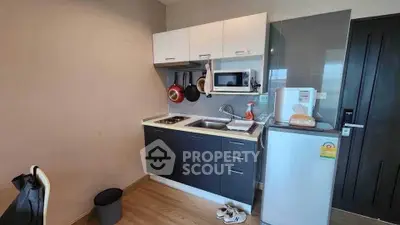 Compact modern kitchen with sleek cabinetry and essential appliances.